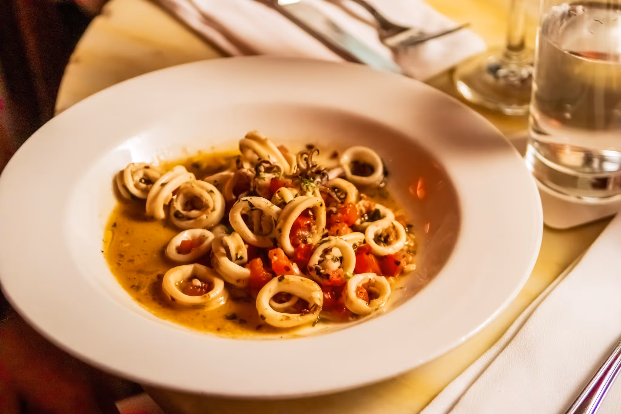 A white plate with a bowl of food on it.