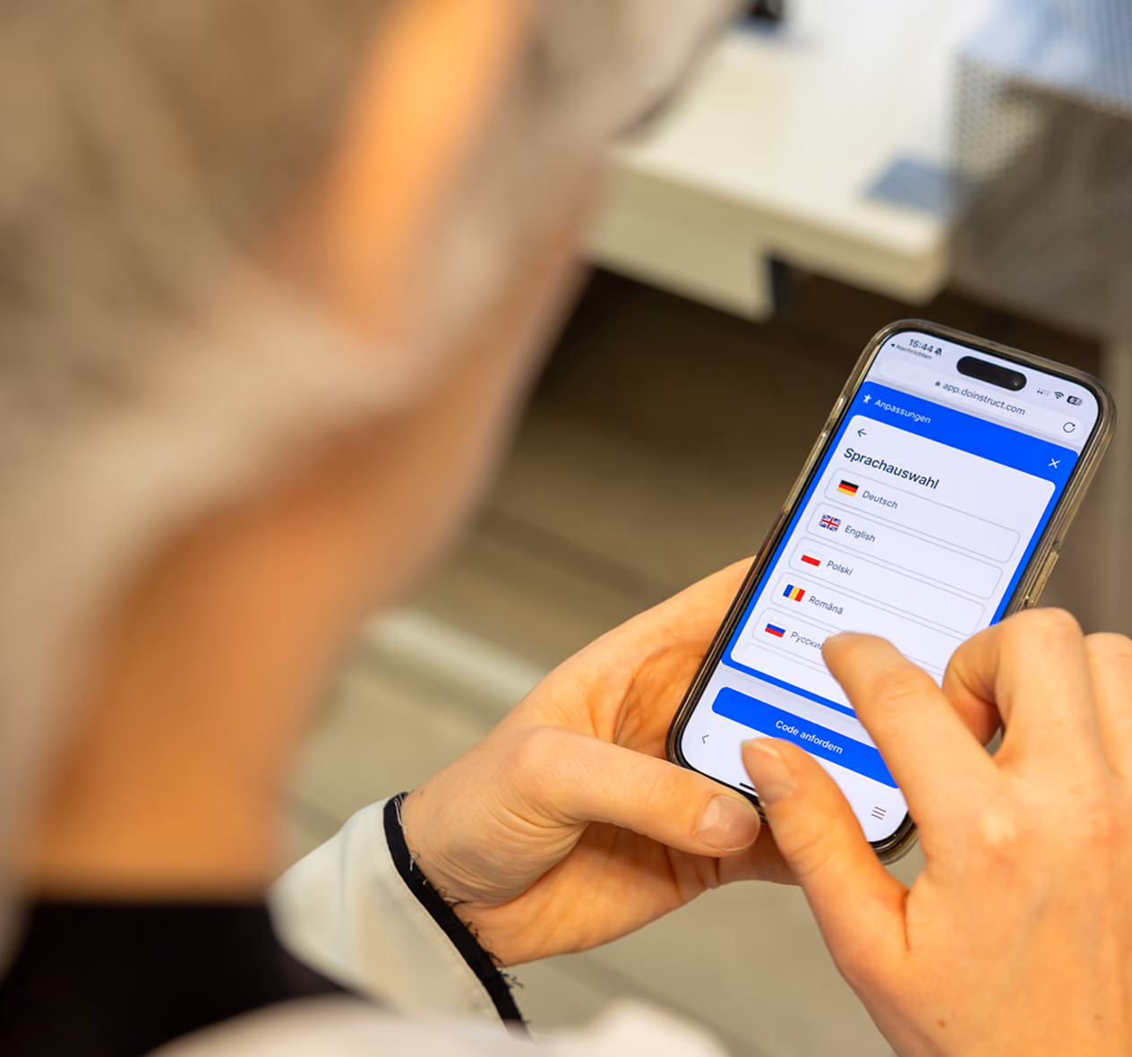 Person selecting a language on a smartphone with a language options menu displayed.