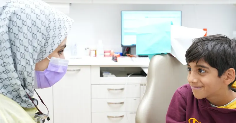 DTC dentist talking with a young patient in the treatment chair