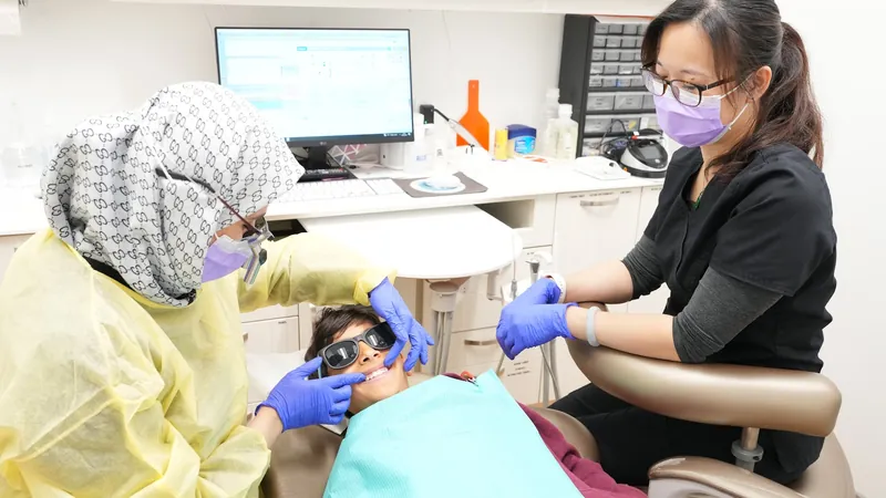 Dentist and dental assistant working together on a patient in the treatment chair at DTC Dental Treatment Center in Richmond, BC