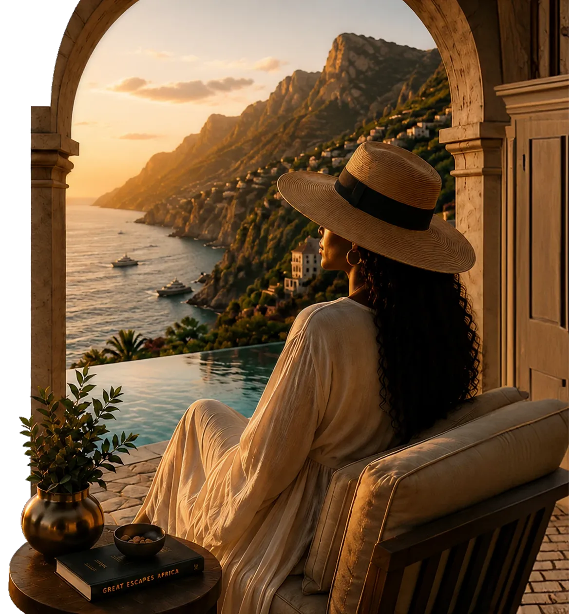 Woman in a wide-brimmed hat sitting by infinity pool overlooking coastal cliffs and yachts at sunset.