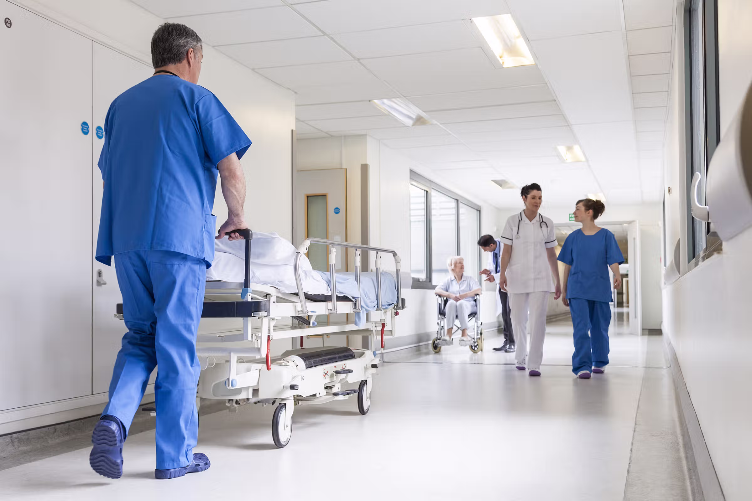 Hospital corridor with clinical rooms and mounted life safety devices in a healthcare facility