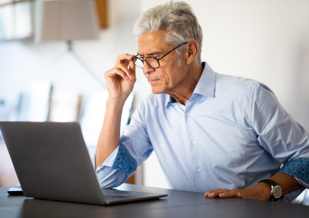 Close up portrait businessman sitting in office looking at laptop computer