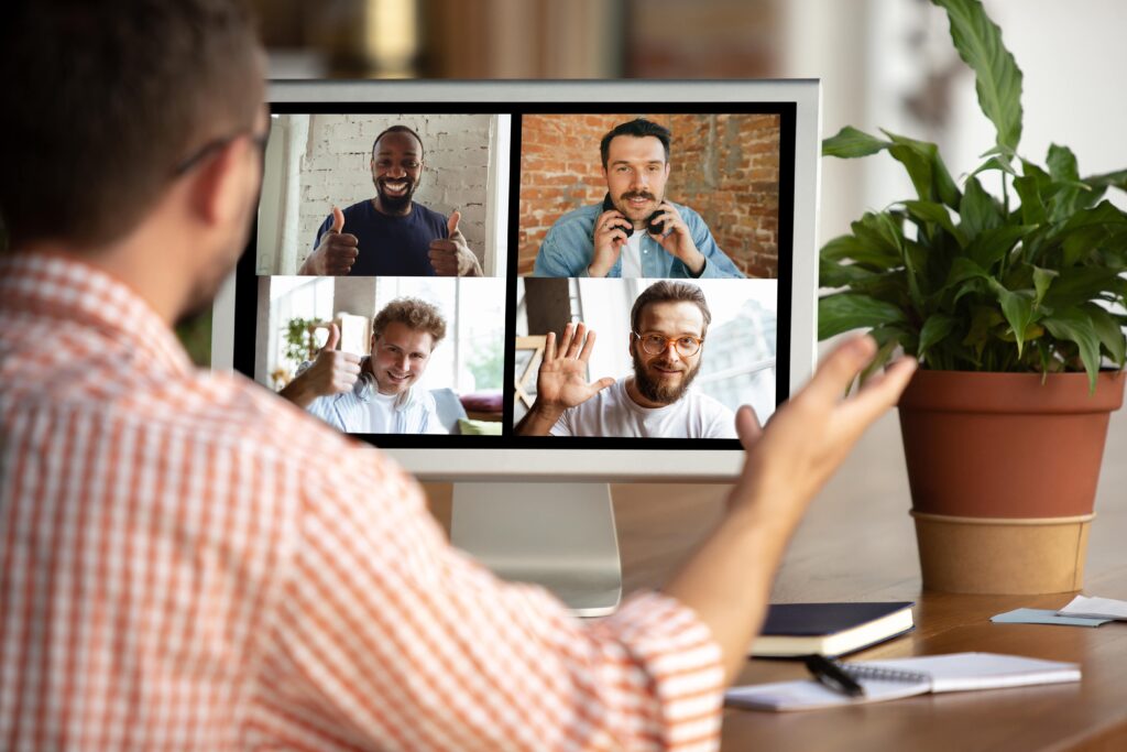 Um homem em uma videochamada com outros quatro homens.