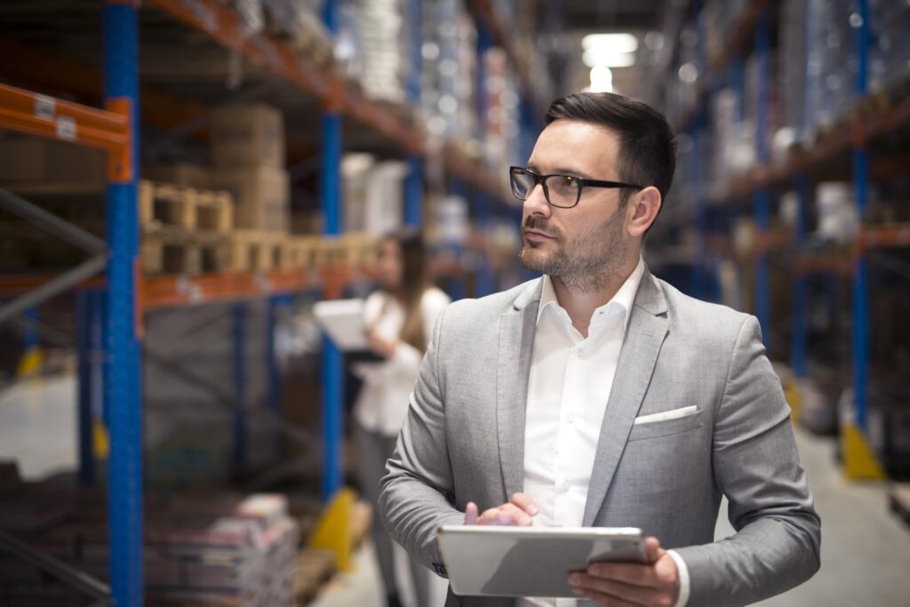Empresário da área de logística usa um tablet para monitorar o estoque da empresa.