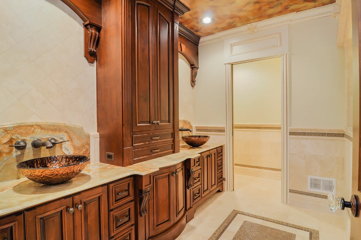A traditional-intricate basement remodel in Franklin, TN. Coffered ceiling, custom carpentry, built-in entertainment unit, fireplace, bar, guest bath, gym, and dining room by Sebring Design Build.