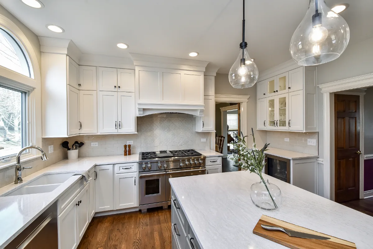 A transitional-refined kitchen in Franklin, TN. CWP Soft White and Tarragon Classic Square Recessed cabinetry, Cambria Ironsbridge Polished quartz, Delta Cassidy Polished Nickel faucet, and Sonoma Stellar Bossy Gray backsplash by Sebring Design.