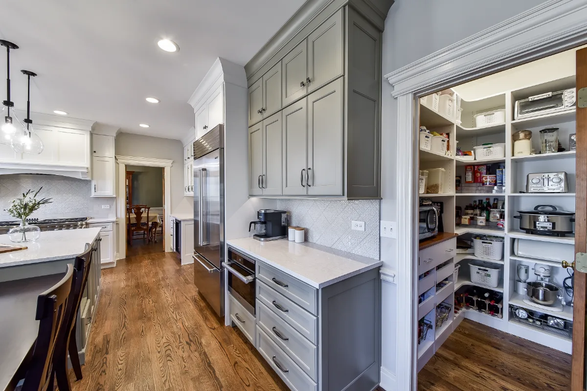 A transitional-refined kitchen in Franklin, TN. CWP Soft White and Tarragon Classic Square Recessed cabinetry, Cambria Ironsbridge Polished quartz, Delta Cassidy Polished Nickel faucet, and Sonoma Stellar Bossy Gray backsplash by Sebring Design.