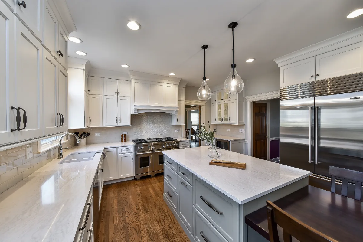 A transitional-refined kitchen in Franklin, TN. CWP Soft White and Tarragon Classic Square Recessed cabinetry, Cambria Ironsbridge Polished quartz, Delta Cassidy Polished Nickel faucet, and Sonoma Stellar Bossy Gray backsplash by Sebring Design.