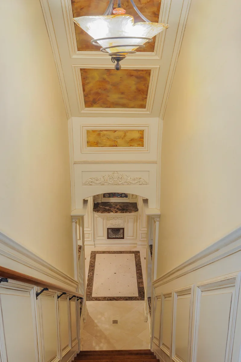 A traditional-intricate basement remodel in Franklin, TN. Coffered ceiling, custom carpentry, built-in entertainment unit, fireplace, bar, guest bath, gym, and dining room by Sebring Design Build.