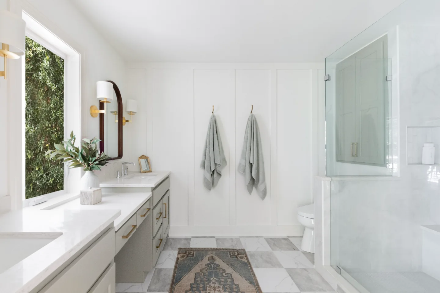 A modern-soft-luxurious primary bath in Leiper's Fork, TN 37069. CWP Mourning Dove Standard Overlay cabinetry, Metro Quartz Mystique scalloped countertops, Delta Chrome fixtures, and Carrera White 13x13 porcelain floor tile by Sebring Design Build.