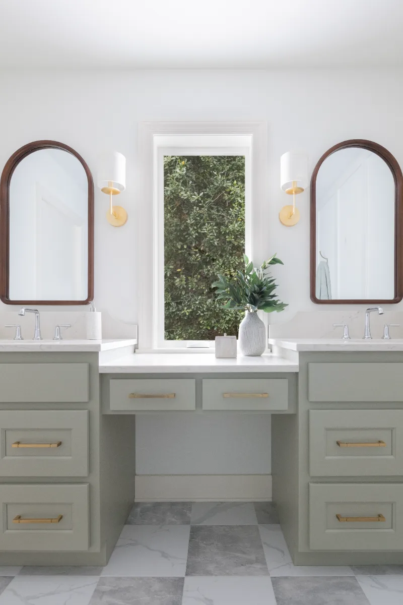 A modern-soft-luxurious primary bath in Leiper's Fork, TN 37069. CWP Mourning Dove Standard Overlay cabinetry, Metro Quartz Mystique scalloped countertops, Delta Chrome fixtures, and Carrera White 13x13 porcelain floor tile by Sebring Design Build.