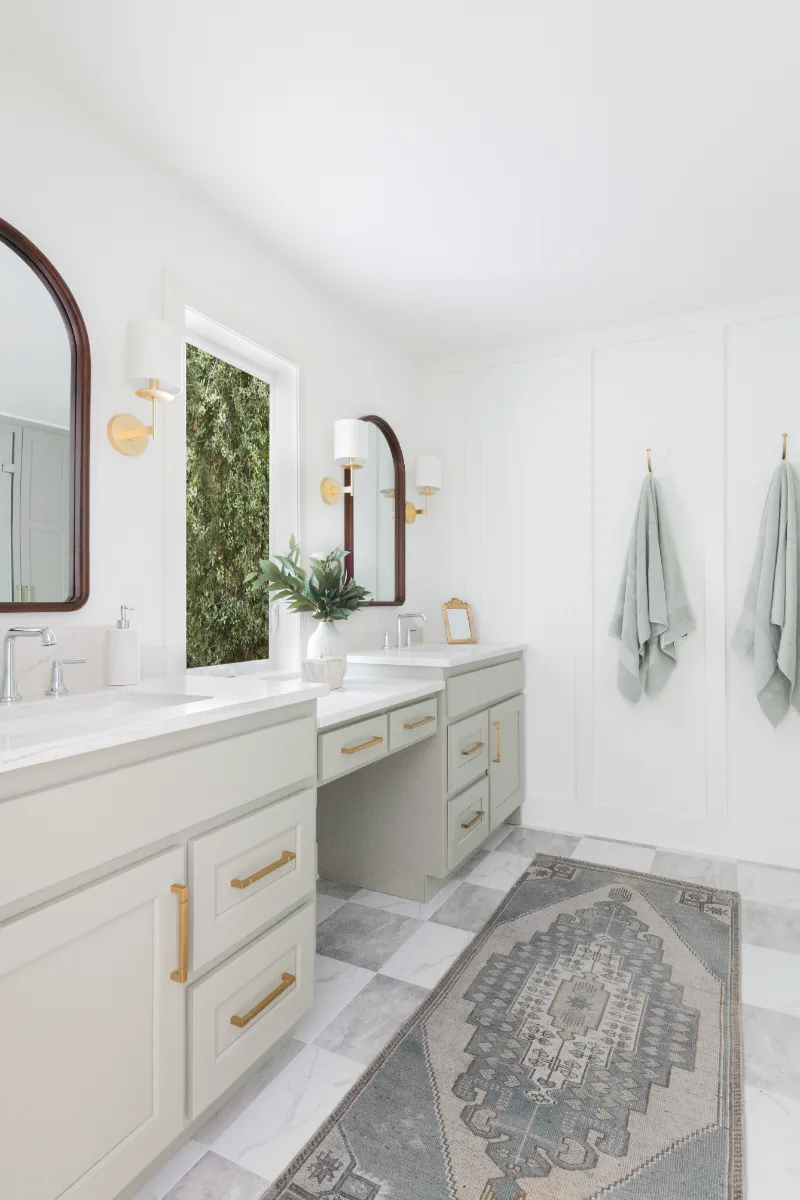 A modern-soft-luxurious primary bath in Leiper's Fork, TN 37069. CWP Mourning Dove Standard Overlay cabinetry, Metro Quartz Mystique scalloped countertops, Delta Chrome fixtures, and Carrera White 13x13 porcelain floor tile by Sebring Design Build.