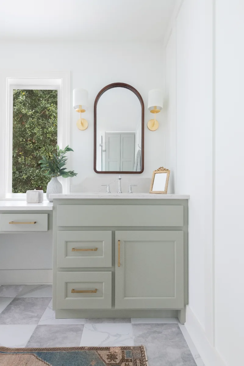 A modern-soft-luxurious primary bath in Leiper's Fork, TN 37069. CWP Mourning Dove Standard Overlay cabinetry, Metro Quartz Mystique scalloped countertops, Delta Chrome fixtures, and Carrera White 13x13 porcelain floor tile by Sebring Design Build.