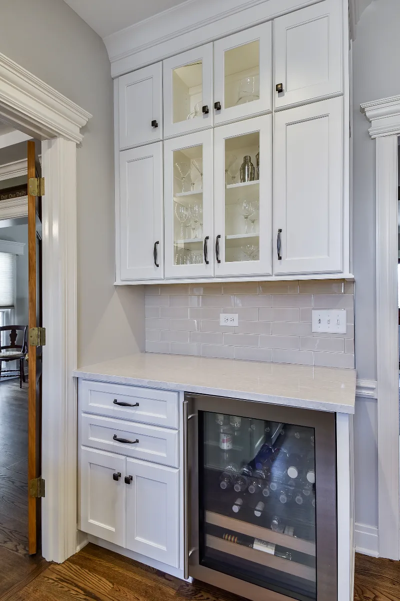 A transitional-refined kitchen in Franklin, TN. CWP Soft White and Tarragon Classic Square Recessed cabinetry, Cambria Ironsbridge Polished quartz, Delta Cassidy Polished Nickel faucet, and Sonoma Stellar Bossy Gray backsplash by Sebring Design.
