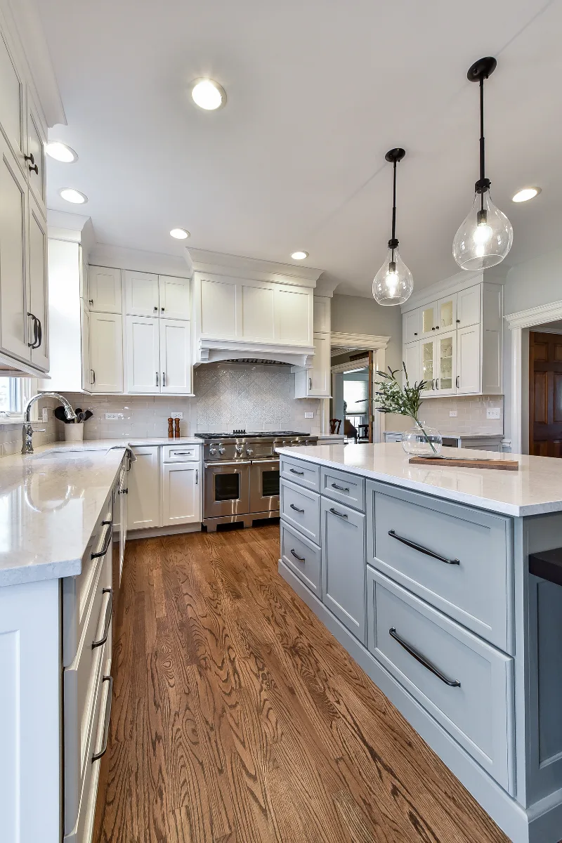 A transitional-refined kitchen in Franklin, TN. CWP Soft White and Tarragon Classic Square Recessed cabinetry, Cambria Ironsbridge Polished quartz, Delta Cassidy Polished Nickel faucet, and Sonoma Stellar Bossy Gray backsplash by Sebring Design.