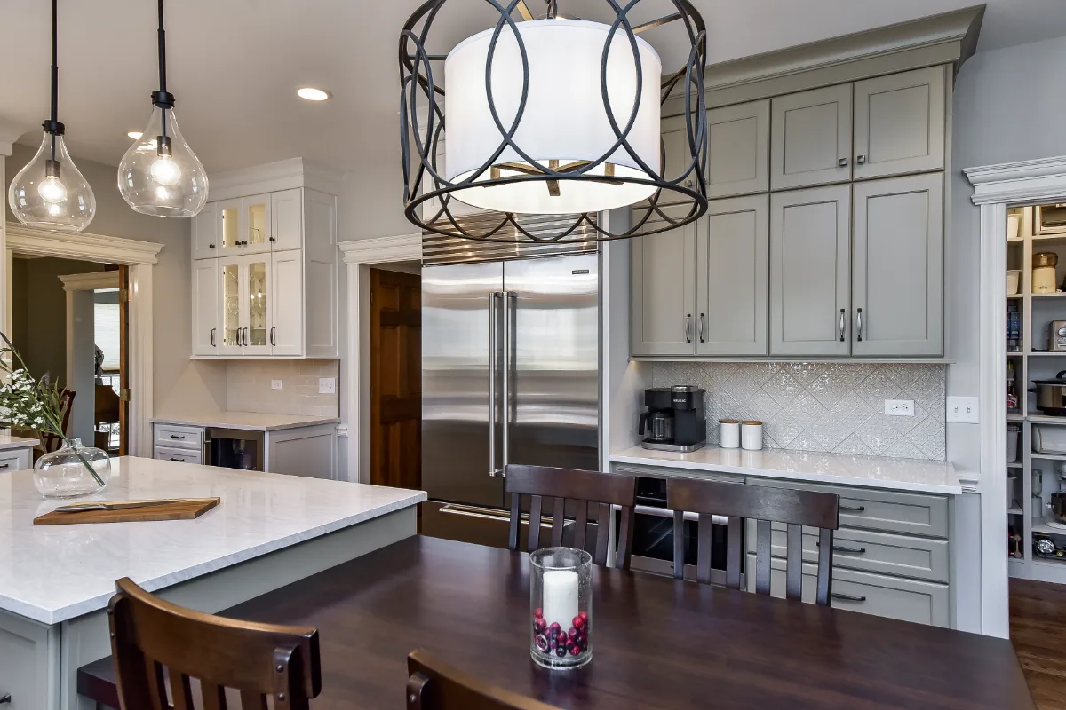 A transitional-refined kitchen in Franklin, TN. CWP Soft White and Tarragon Classic Square Recessed cabinetry, Cambria Ironsbridge Polished quartz, Delta Cassidy Polished Nickel faucet, and Sonoma Stellar Bossy Gray backsplash by Sebring Design.