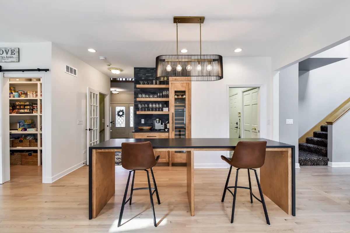 A modern-rustic home bar in Brentwood, TN. Bunker Hill Black CWP cabinetry, Cambria Colton Polished quartz, Flat Black Riverside pulls, floating shelves, and Ledger Stone Carbon backsplash by Sebring Design Build.