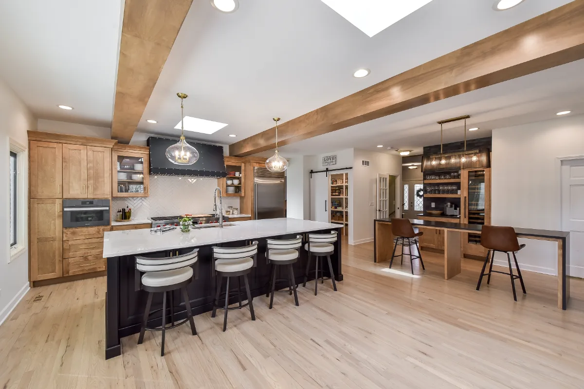 A modern-rustic kitchen in Brentwood, TN. CWP Fruitwood on Birch and Bunker Hill Black cabinetry, Cambria Charlestown Matte and Colton Polished quartz, Kohler Tournant faucet, and Ledger Stone Carbon backsplash by Sebring Design Build.
