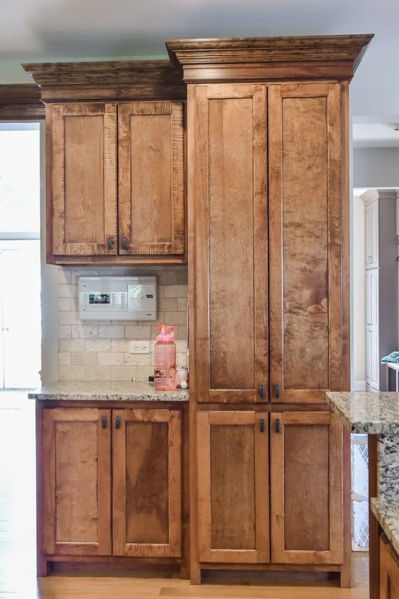 A modern-elegant home bar in Brentwood, TN. Ebony Shaker cabinetry, Corian Quartz Calcutta Natural, and Kohler Vibrant Brushed Moderne Brass by Sebring Design Build.
