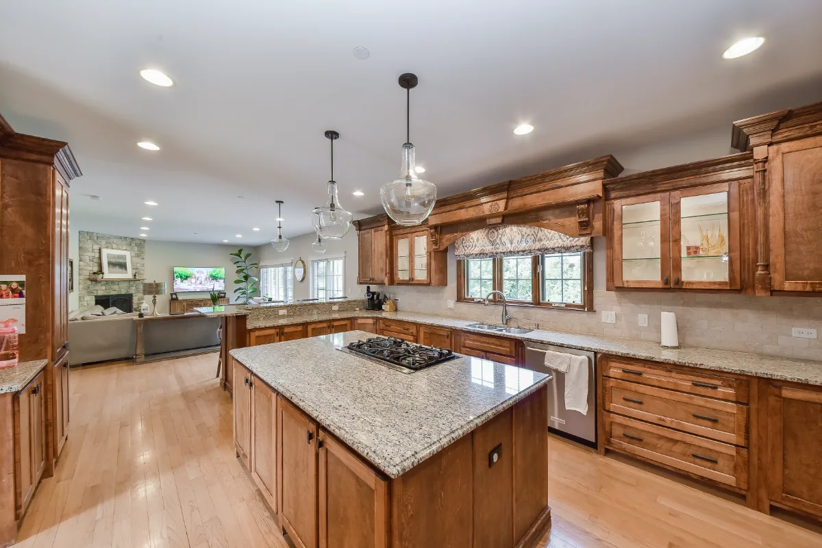 A modern-elegant kitchen in Brentwood, TN. Paint-grade Ebony and Soft White Shaker cabinetry, Corian Quartz Calcutta Natural, Kohler Vibrant Brushed Moderne Brass faucet, and Crafted Snow Gloss 2x10 backsplash by Sebring Design Build.