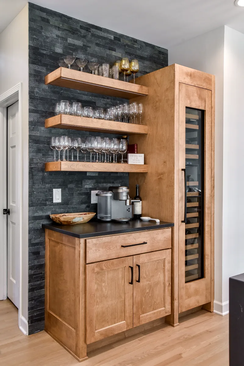 A modern-rustic home bar in Brentwood, TN. Bunker Hill Black CWP cabinetry, Cambria Colton Polished quartz, Flat Black Riverside pulls, floating shelves, and Ledger Stone Carbon backsplash by Sebring Design Build.