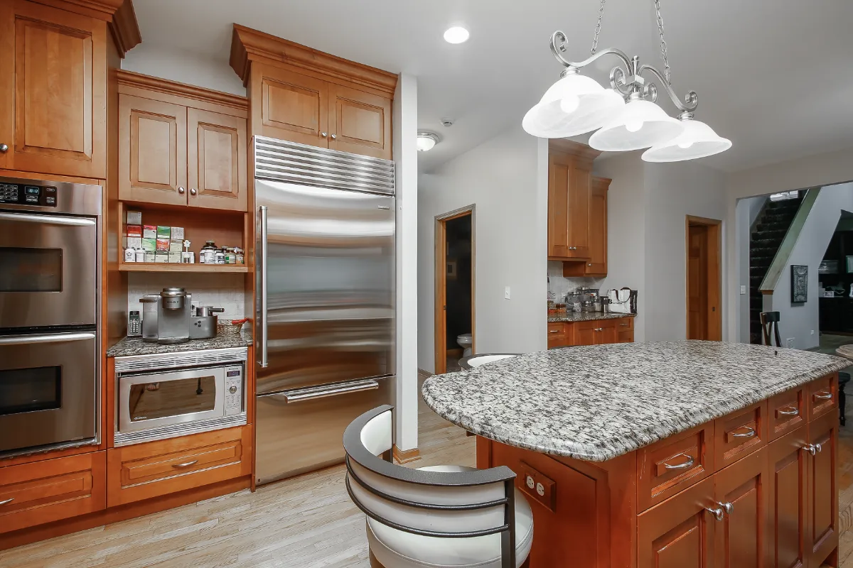A modern-rustic kitchen in Brentwood, TN. CWP Fruitwood on Birch and Bunker Hill Black cabinetry, Cambria Charlestown Matte and Colton Polished quartz, Kohler Tournant faucet, and Ledger Stone Carbon backsplash by Sebring Design Build.
