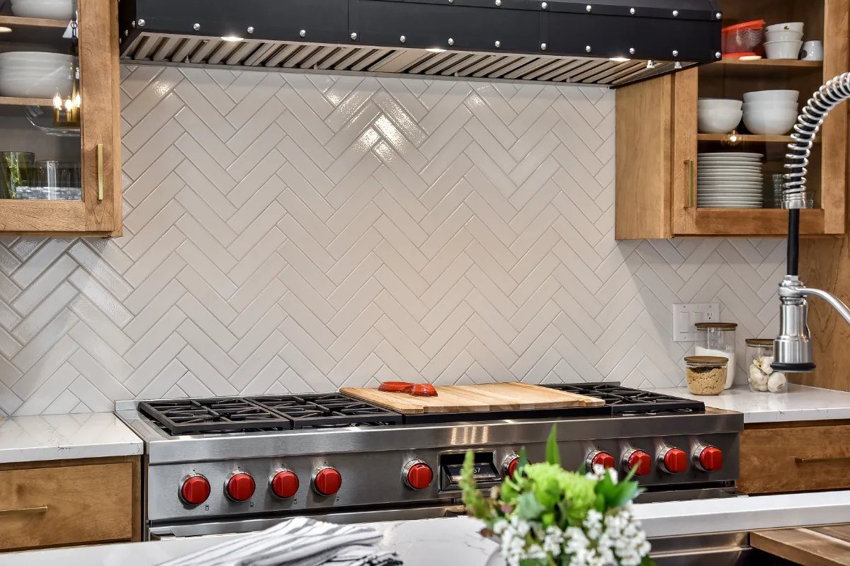 A modern-rustic kitchen in Brentwood, TN. CWP Fruitwood on Birch and Bunker Hill Black cabinetry, Cambria Charlestown Matte and Colton Polished quartz, Kohler Tournant faucet, and Ledger Stone Carbon backsplash by Sebring Design Build.
