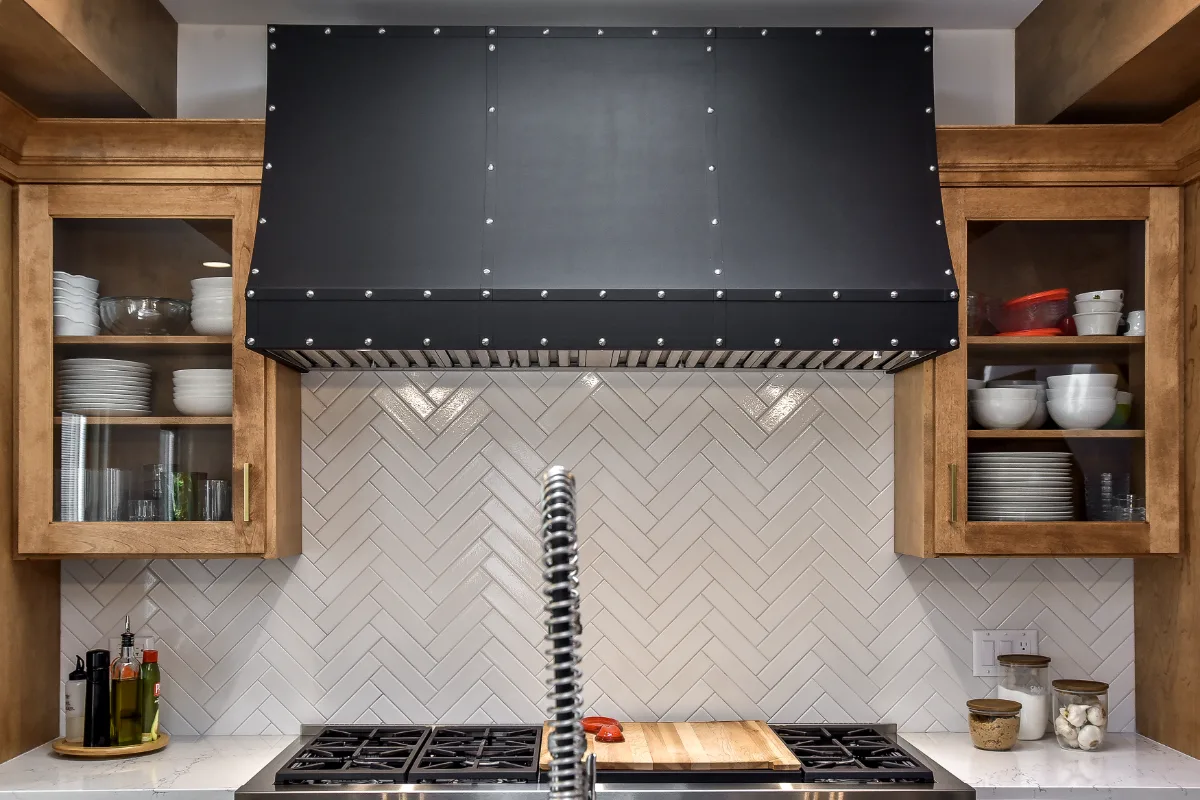 A modern-rustic kitchen in Brentwood, TN. CWP Fruitwood on Birch and Bunker Hill Black cabinetry, Cambria Charlestown Matte and Colton Polished quartz, Kohler Tournant faucet, and Ledger Stone Carbon backsplash by Sebring Design Build.