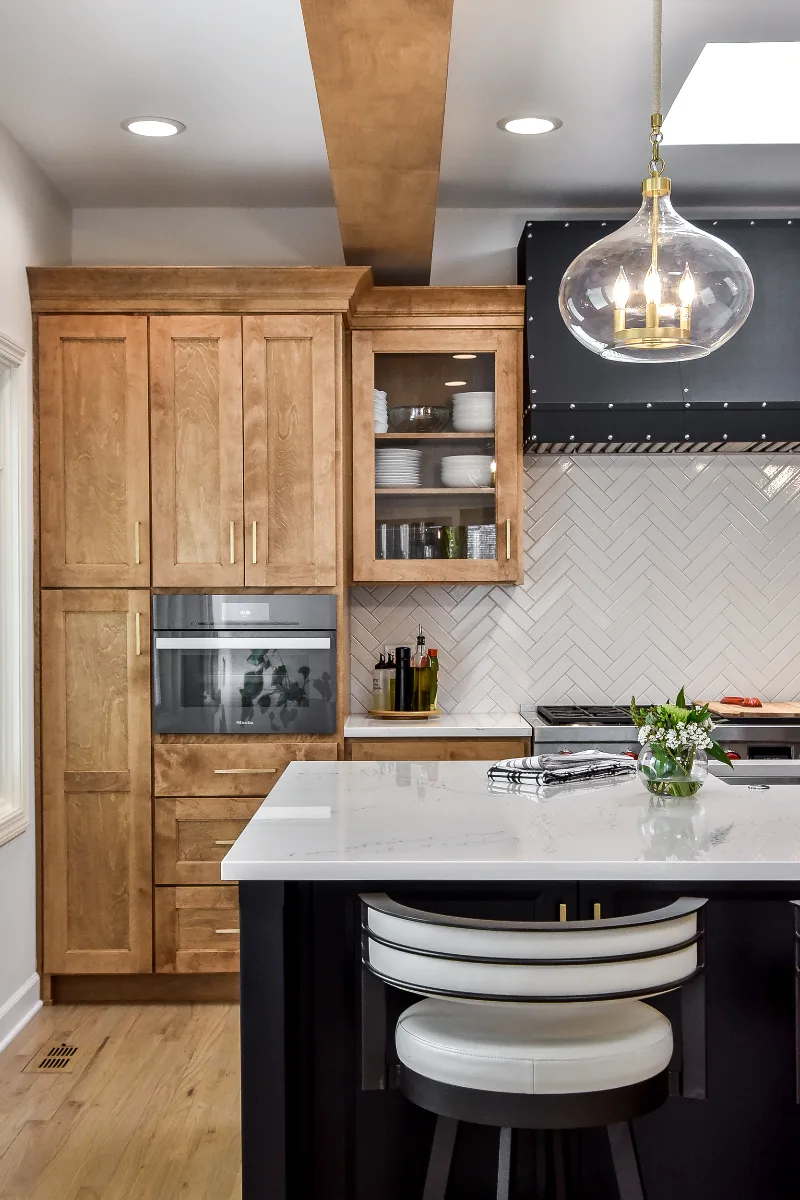 A modern-rustic kitchen in Brentwood, TN. CWP Fruitwood on Birch and Bunker Hill Black cabinetry, Cambria Charlestown Matte and Colton Polished quartz, Kohler Tournant faucet, and Ledger Stone Carbon backsplash by Sebring Design Build.