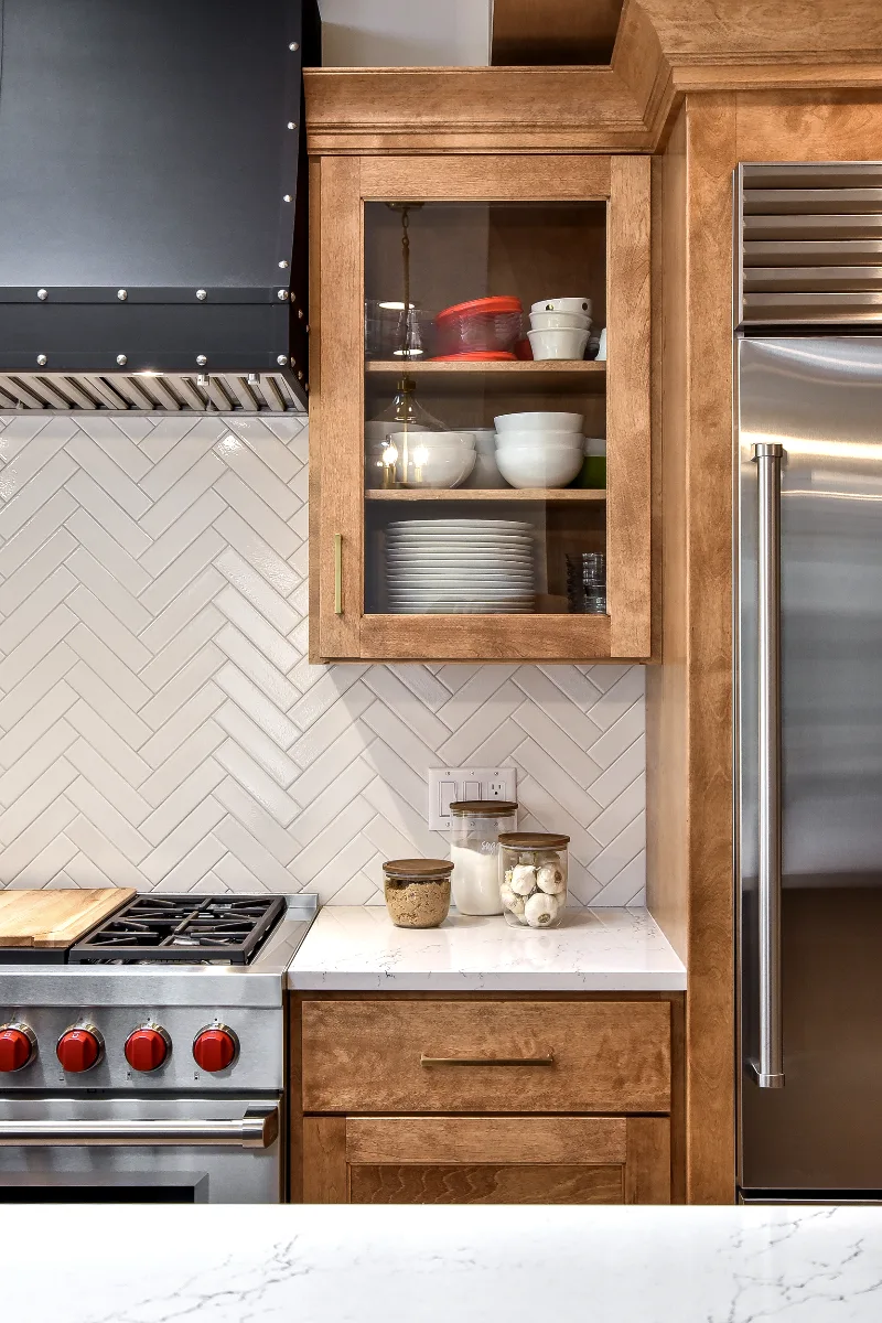 A modern-rustic kitchen in Brentwood, TN. CWP Fruitwood on Birch and Bunker Hill Black cabinetry, Cambria Charlestown Matte and Colton Polished quartz, Kohler Tournant faucet, and Ledger Stone Carbon backsplash by Sebring Design Build.