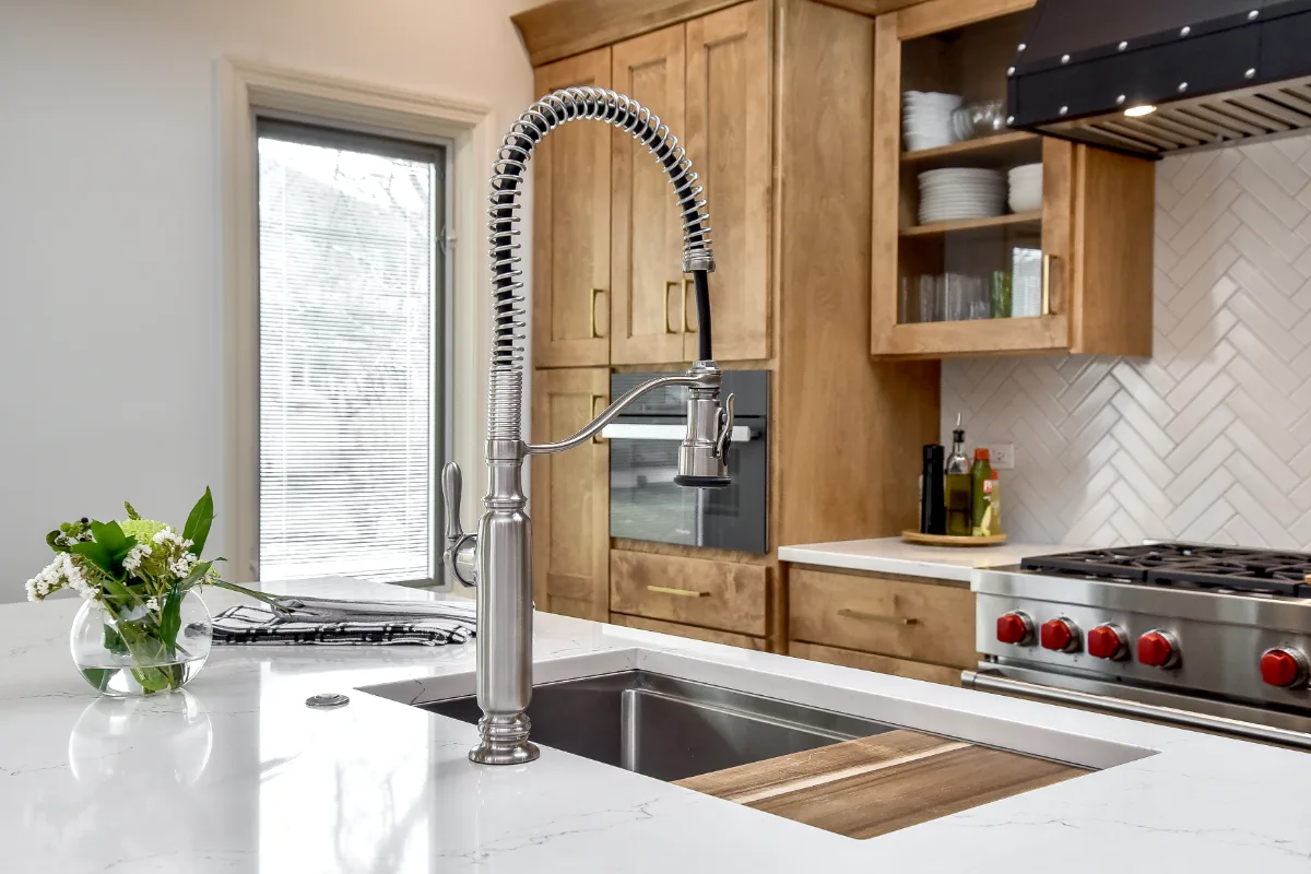A modern-rustic kitchen in Brentwood, TN. CWP Fruitwood on Birch and Bunker Hill Black cabinetry, Cambria Charlestown Matte and Colton Polished quartz, Kohler Tournant faucet, and Ledger Stone Carbon backsplash by Sebring Design Build.