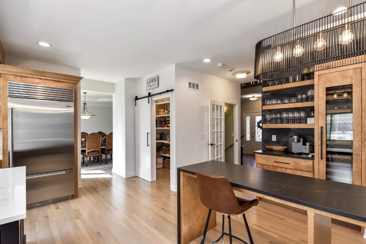 A modern-rustic kitchen in Brentwood, TN. CWP Fruitwood on Birch and Bunker Hill Black cabinetry, Cambria Charlestown Matte and Colton Polished quartz, Kohler Tournant faucet, and Ledger Stone Carbon backsplash by Sebring Design Build.