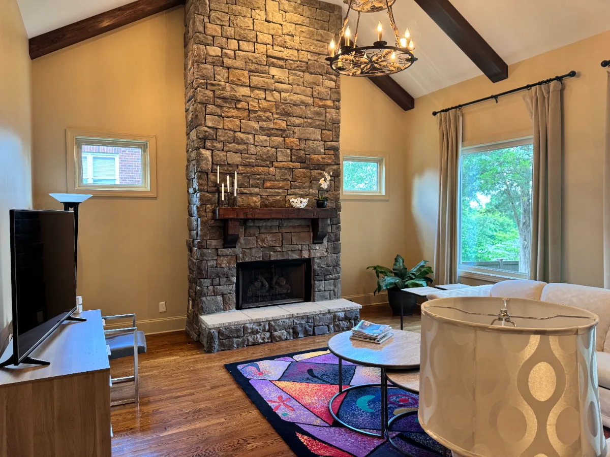A contemporary-unique living room in Westhaven, Franklin TN 37064. Bold fireplace with Essential Graphite 24x48 tile, Alder Nutmeg wood slats and mantle, Siberia White Leathered hearth, and Schluter Dark Anthracite trim by Sebring Design Build.