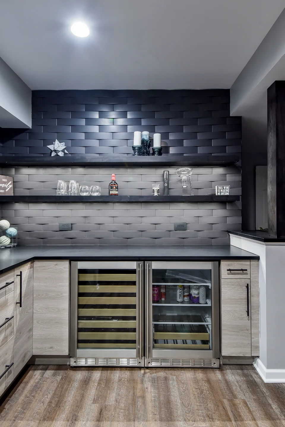 A transitional-unique basement bar with integrated wine cellar in Brentwood, TN. Bellmont Coastal Terra cabinetry, Cambria Blackpool matte quartz, and Amerock Matte Black hardware by Sebring Design Build.