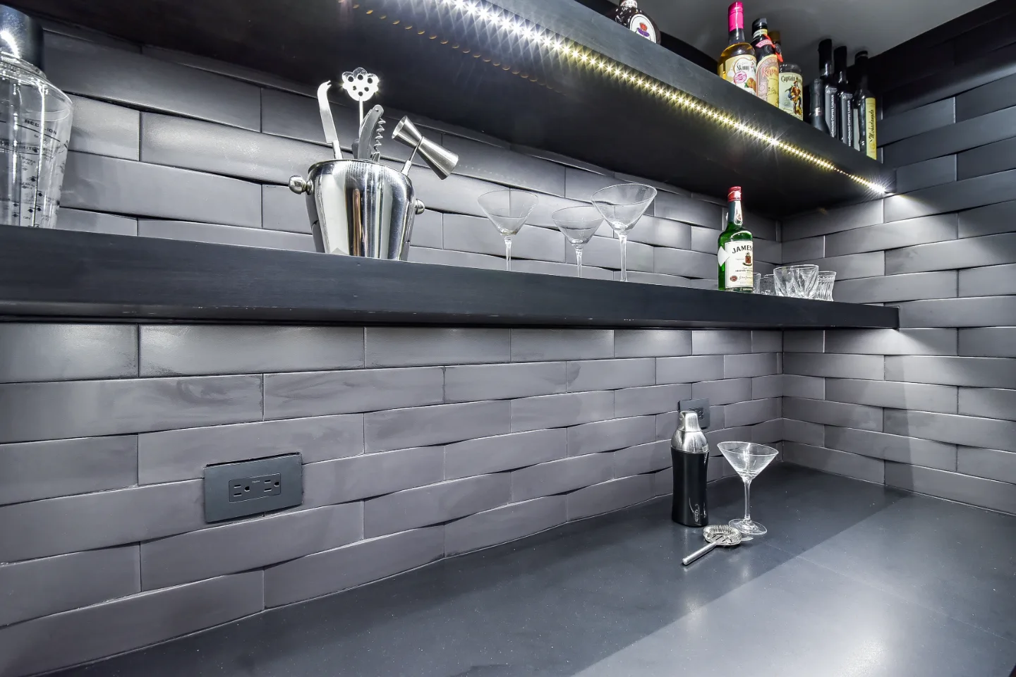 A transitional-unique basement bar with integrated wine cellar in Brentwood, TN. Bellmont Coastal Terra cabinetry, Cambria Blackpool matte quartz, and Amerock Matte Black hardware by Sebring Design Build.