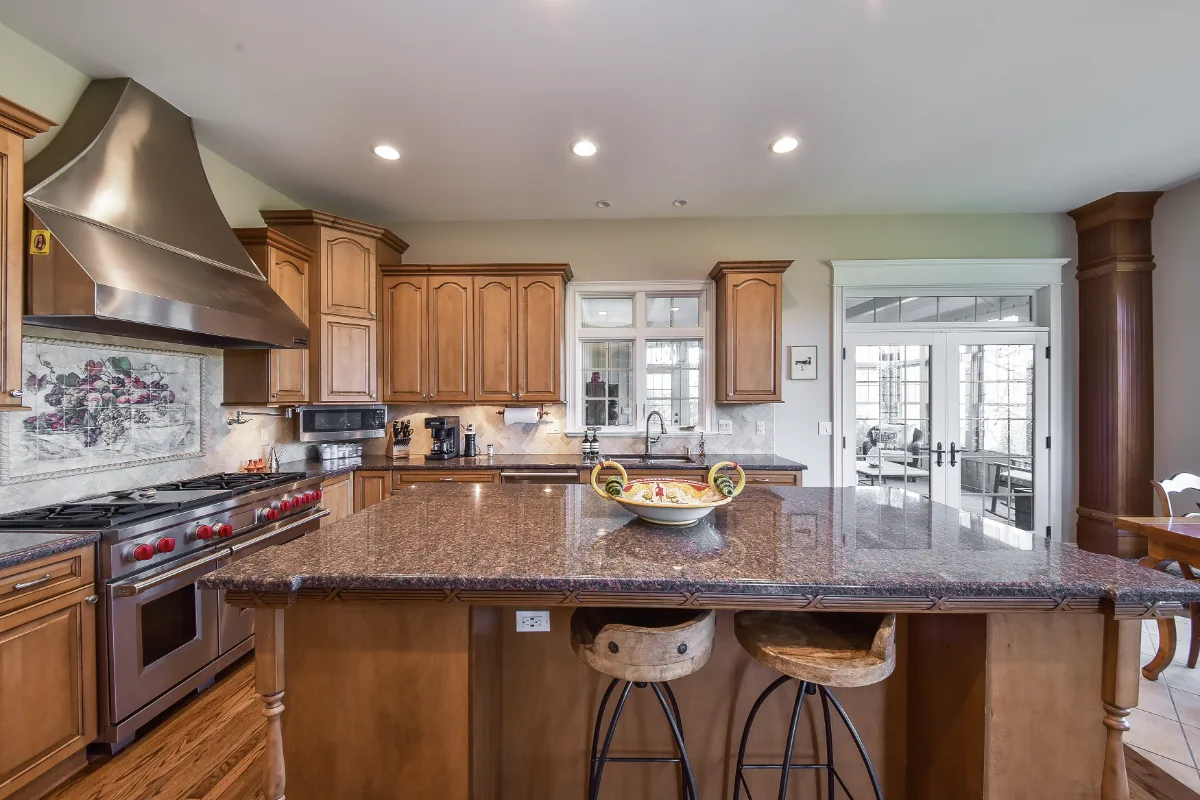 A transitional-elegant kitchen in Brentwood, TN. CWP Fawn Brindle and Walnut Praline cabinetry, CaesarStone Statuario Nuvo honed quartz, Kohler Artifacts Polished Nickel, and Daltile Argyle polished backsplash by Sebring Design Build.