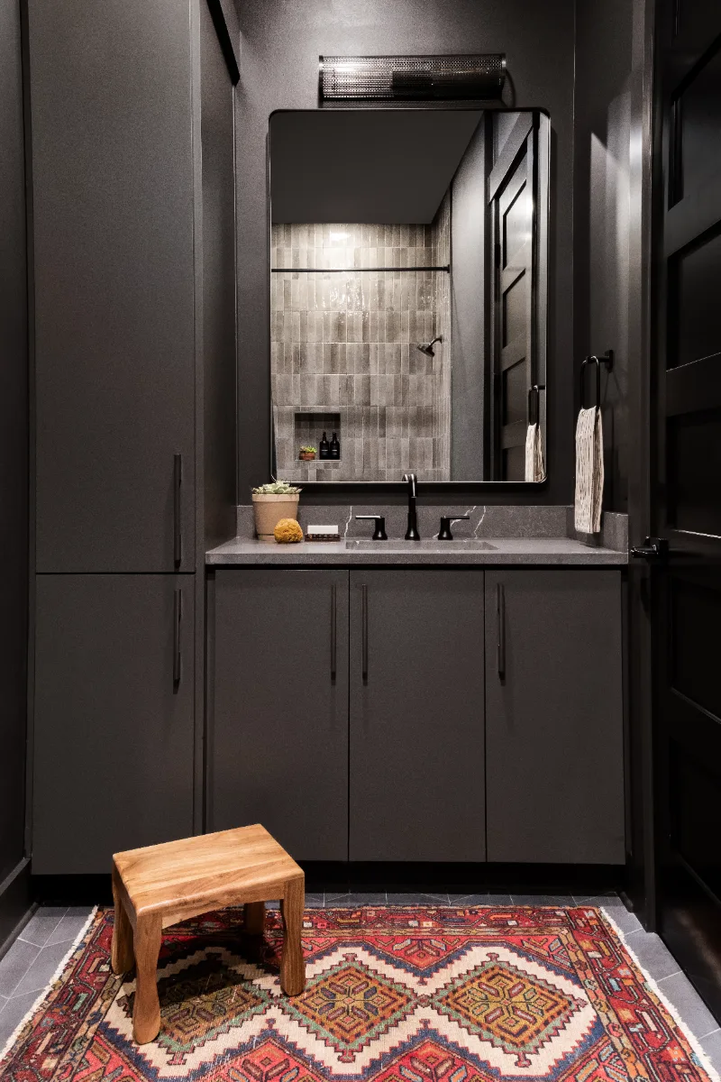 A unique-luxurious guest bath in Columbia, TN. CWP Urbane Bronze Slab cabinetry, Metro Quartz Cemento, Amerock Black Brushed Nickel, Daltile Remedy Zen shower walls, and Kenridge Ribbon Black accent tile by Sebring Design Build.