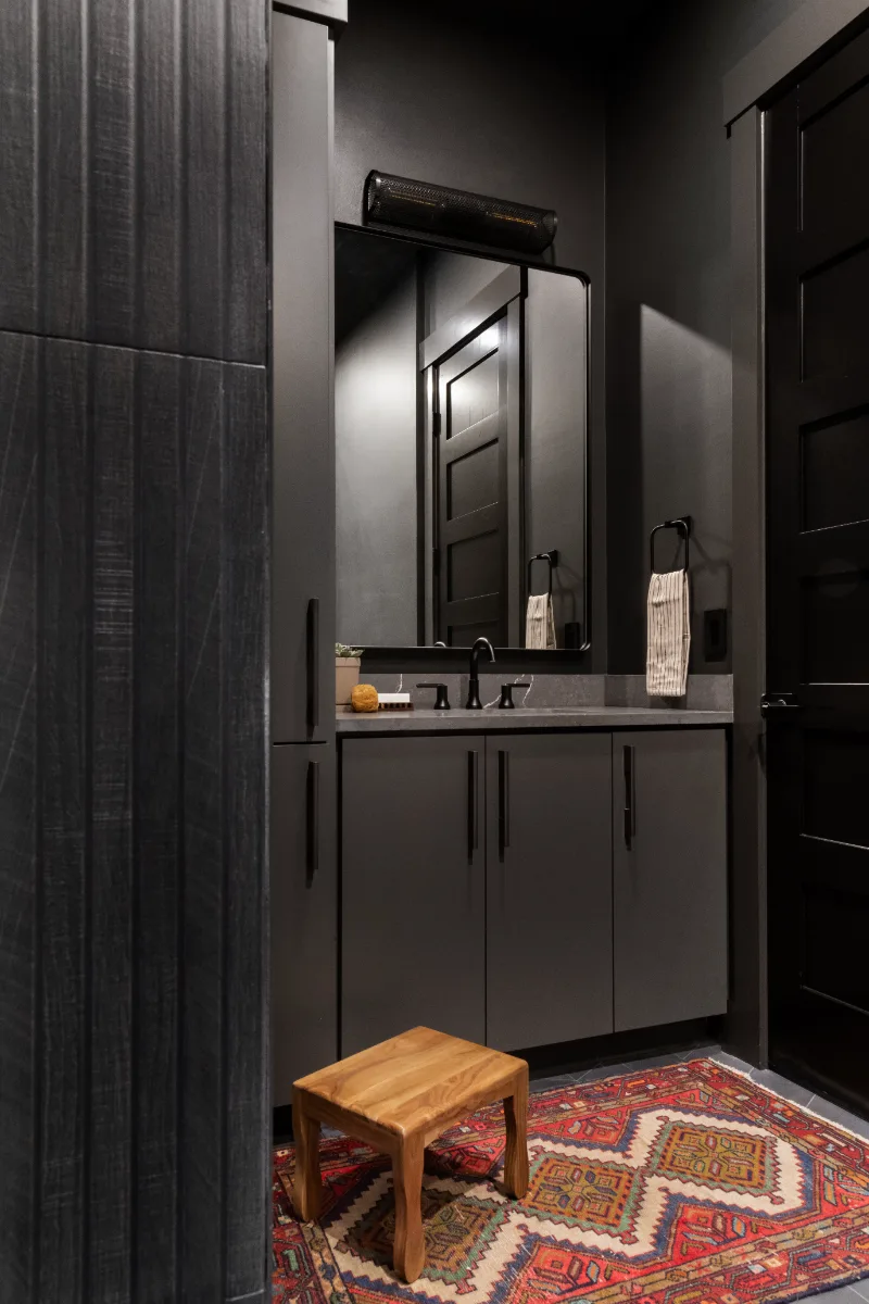 A unique-luxurious guest bath in Columbia, TN. CWP Urbane Bronze Slab cabinetry, Metro Quartz Cemento, Amerock Black Brushed Nickel, Daltile Remedy Zen shower walls, and Kenridge Ribbon Black accent tile by Sebring Design Build.