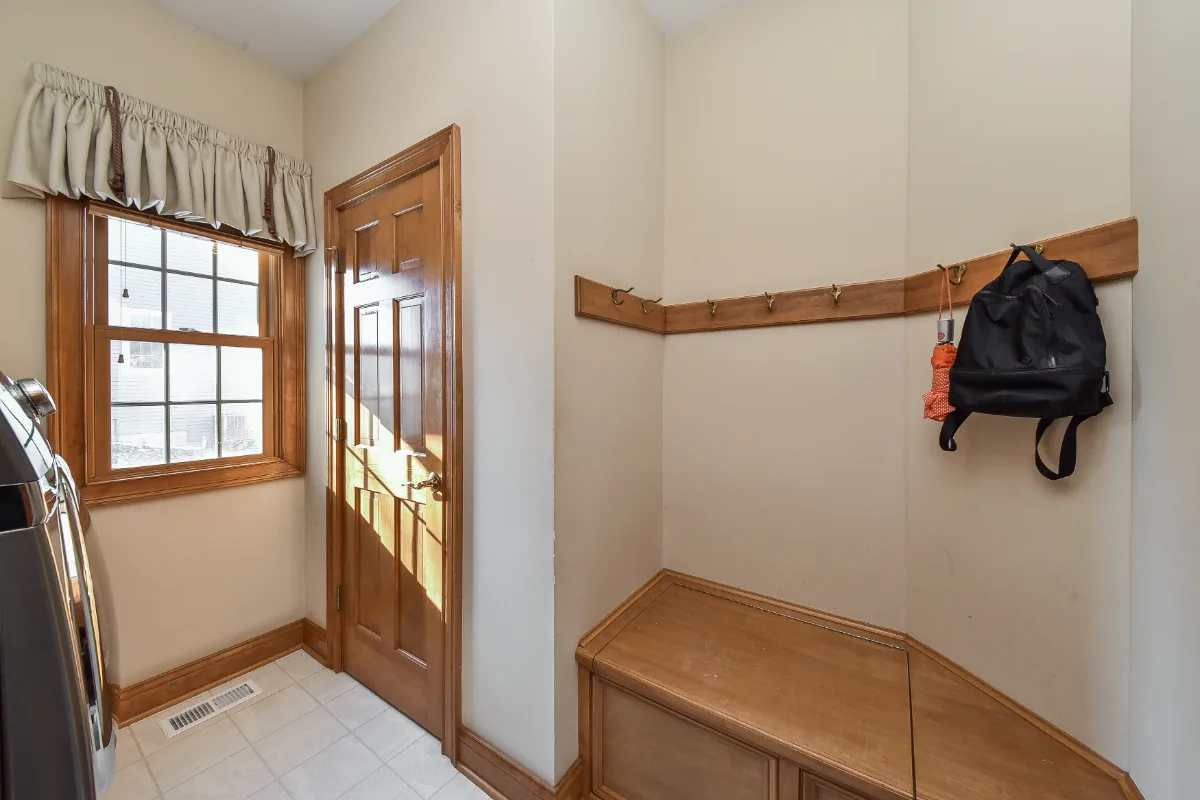 A transitional-functional mudroom in Brentwood, TN. Paint-grade Puget Sound cabinetry, CaesarStone Palm Shade honed quartz, Honey Bronze Top Knobs hardware, and Faroe Mother of Pearl flooring by Sebring Design Build.