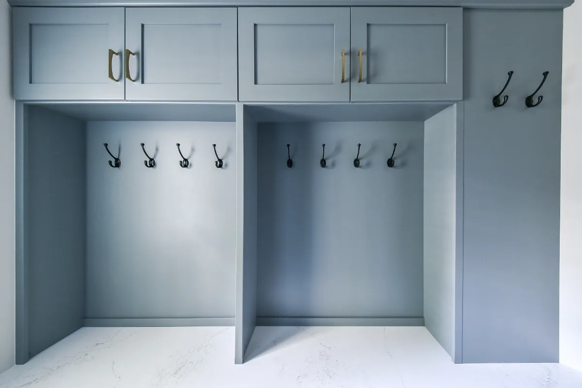 A transitional-functional mudroom in Brentwood, TN. Paint-grade Puget Sound cabinetry, CaesarStone Palm Shade honed quartz, Honey Bronze Top Knobs hardware, and Faroe Mother of Pearl flooring by Sebring Design Build.