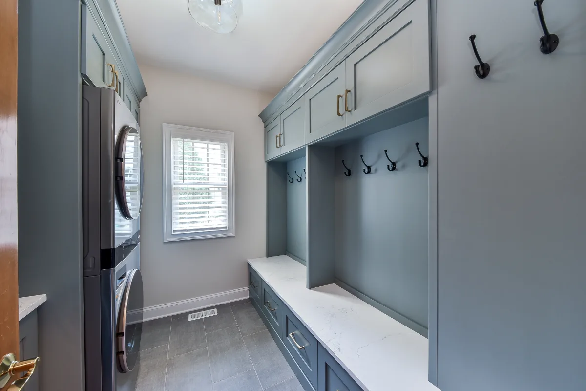 A transitional-functional laundry room in Brentwood, TN. Paint-grade Puget Sound cabinetry, CaesarStone Palm Shade honed quartz, Honey Bronze Top Knobs hardware, and Faroe Mother of Pearl flooring by Sebring Design Build.