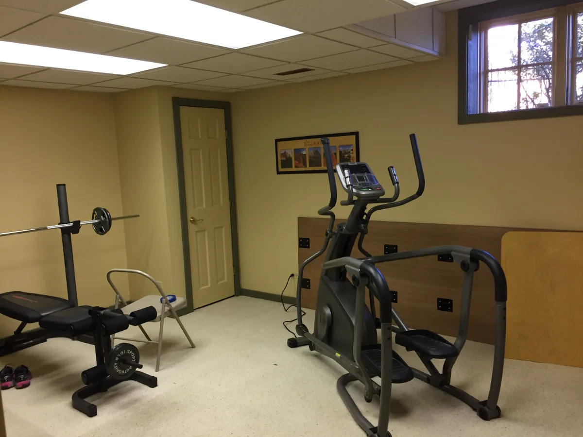 A functional-modern basement gym in Franklin, TN. 5mm recycled rubber bounce flooring and custom wood floating shelves by Sebring Design Build.