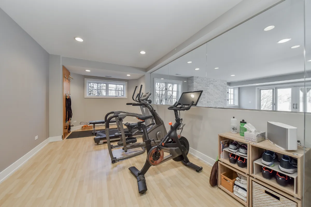 A functional-modern basement gym in Franklin, TN. 5mm recycled rubber bounce flooring and custom wood floating shelves by Sebring Design Build.