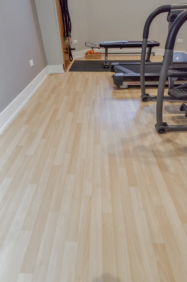 A functional-modern basement gym in Franklin, TN. 5mm recycled rubber bounce flooring and custom wood floating shelves by Sebring Design Build.