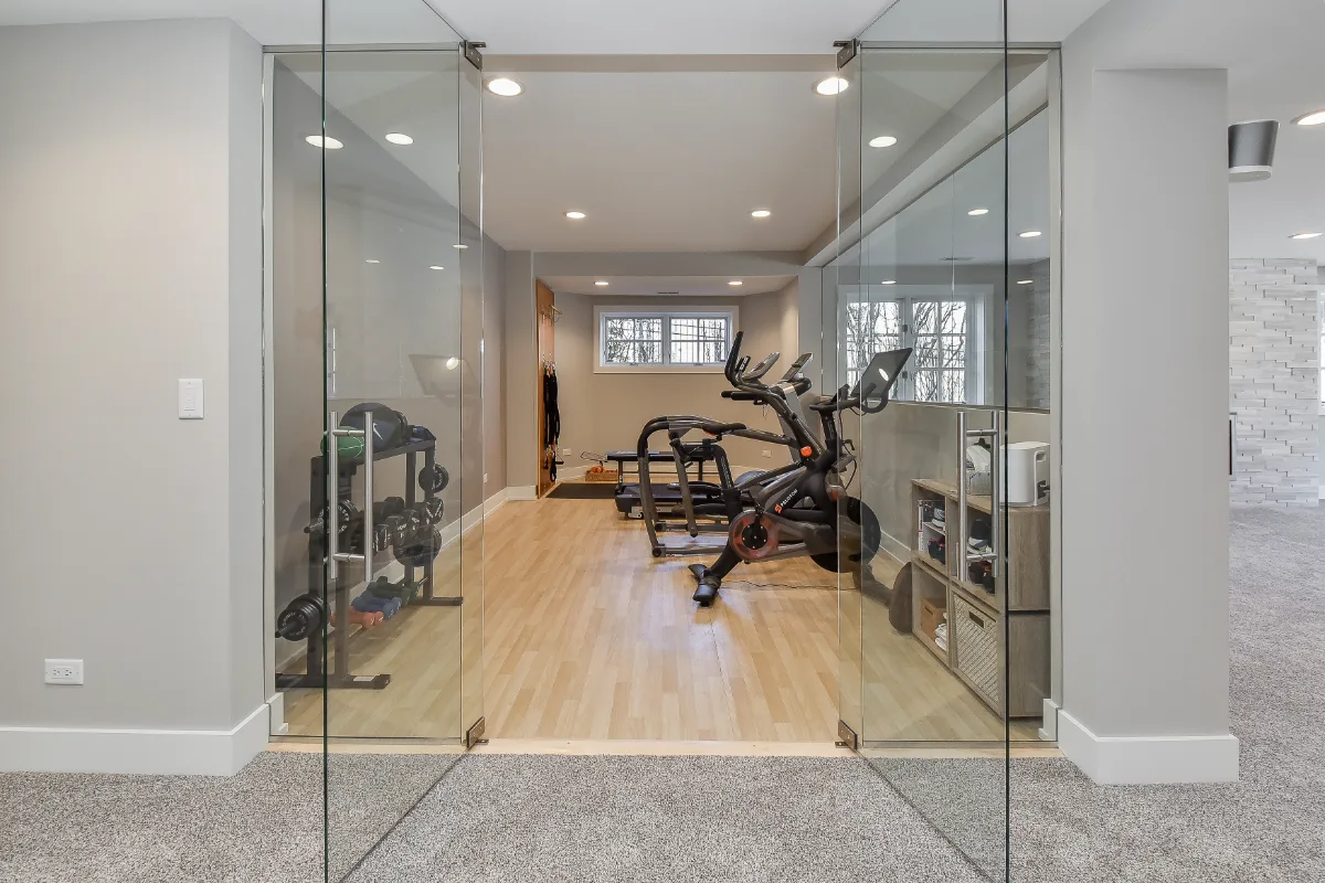 A functional-modern basement gym in Franklin, TN. 5mm recycled rubber bounce flooring and custom wood floating shelves by Sebring Design Build.