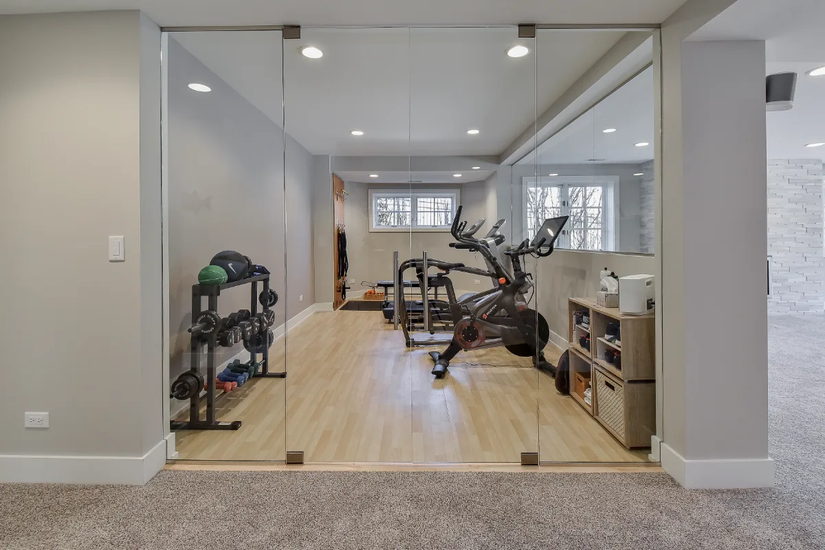 A functional-modern basement gym in Franklin, TN. 5mm recycled rubber bounce flooring and custom wood floating shelves by Sebring Design Build.