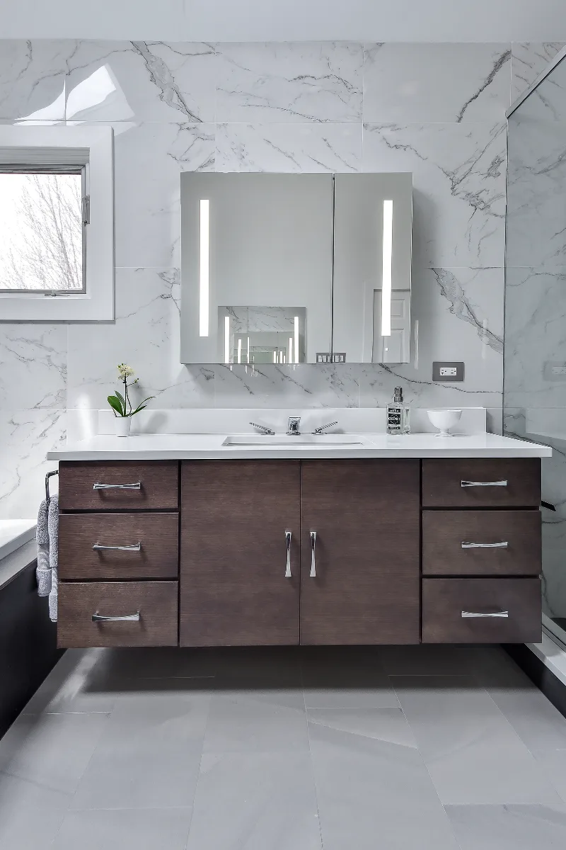 A modern-crisp primary bath remodel in Brentwood, TN. Wellborn Barcelona Oak Drift cabinetry, Orion Absolute White quartz, Atlas Concorde Calacatta Extra vanity wall, and Polished Chrome fixtures by Sebring Design Build.