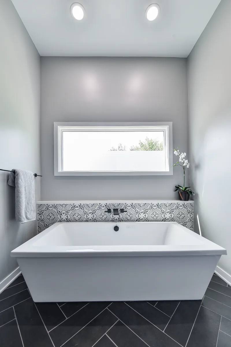 A modern-black-white primary bath remodel in Franklin, TN. Bellmont 1600 Studio White cabinetry, Cambria Deligatie quartz, Kohler Pivotal Matte Black, MTI Andrea tub, and MSI Kenzzi Paloma tile by Sebring Design Build.