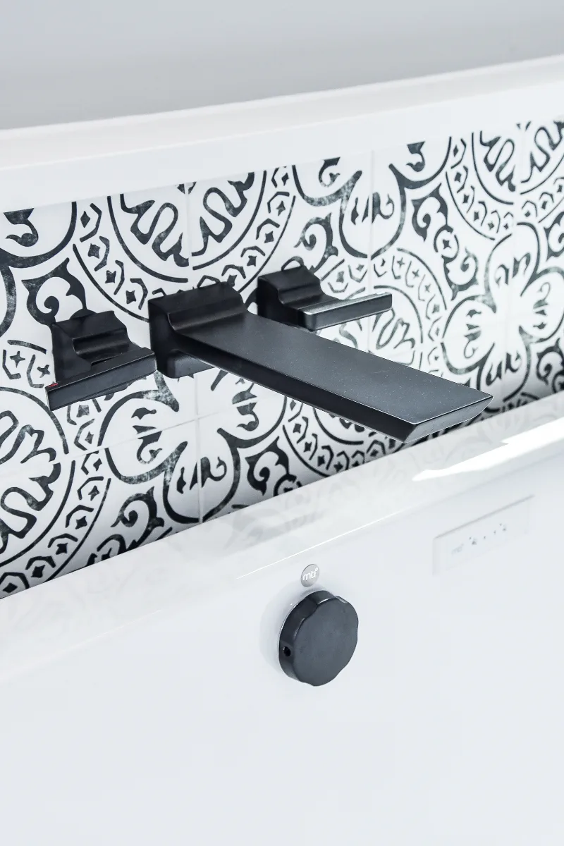 A modern-black-white primary bath remodel in Franklin, TN. Bellmont 1600 Studio White cabinetry, Cambria Deligatie quartz, Kohler Pivotal Matte Black, MTI Andrea tub, and MSI Kenzzi Paloma tile by Sebring Design Build.